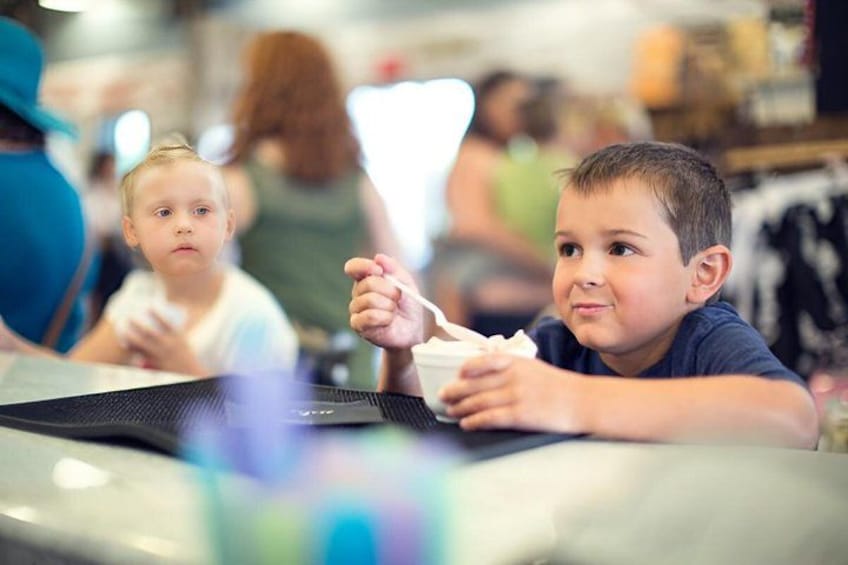 Two children sitting at a table in a store with a laptop and a smartphone. 3