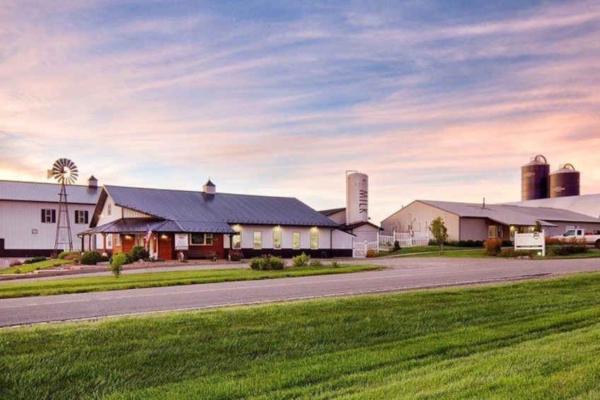 A farmstead with barns, a windmill, and silo structures. 1
