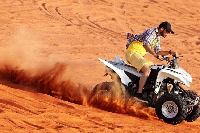 A person riding an ATV on a sandy terrain. 3