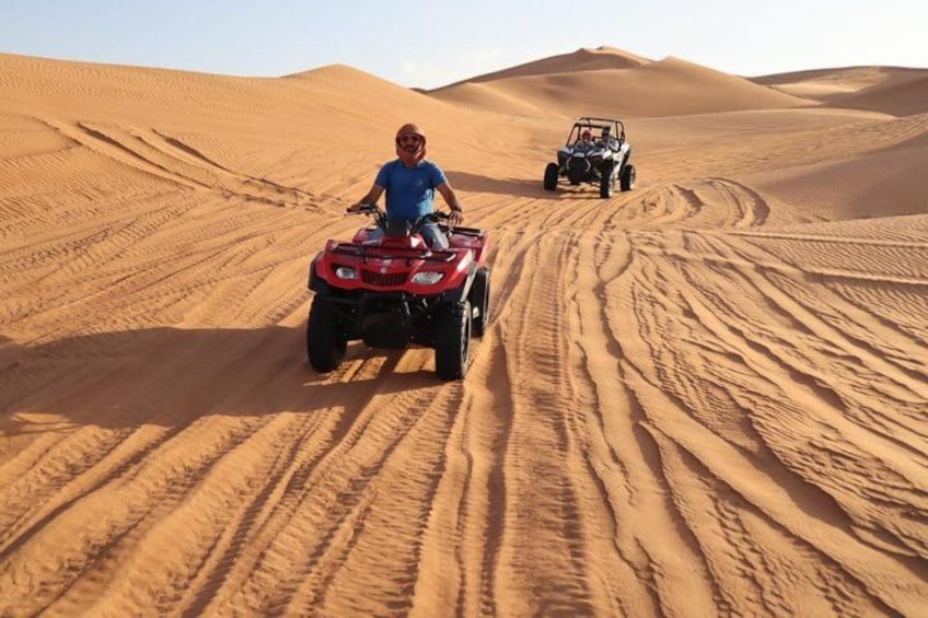 A desert landscape with sand dunes and two off-road vehicles. 2