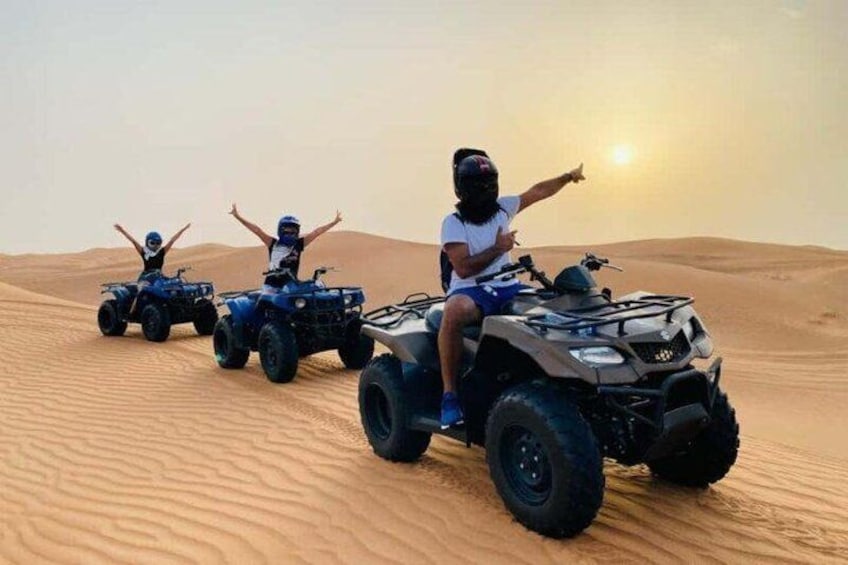 Three people on ATVs in a desert with sand dunes. 5
