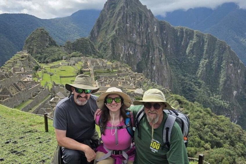 A group of people on a mountain trail with Machu Picchu in the background. 5