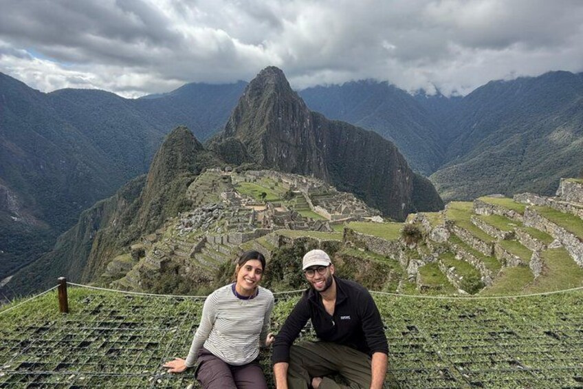 Two people sitting on a terrace with Machu Picchu in the background. 3