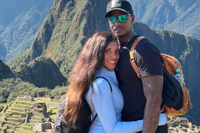 A couple embracing with a mountainous landscape in the background. 2