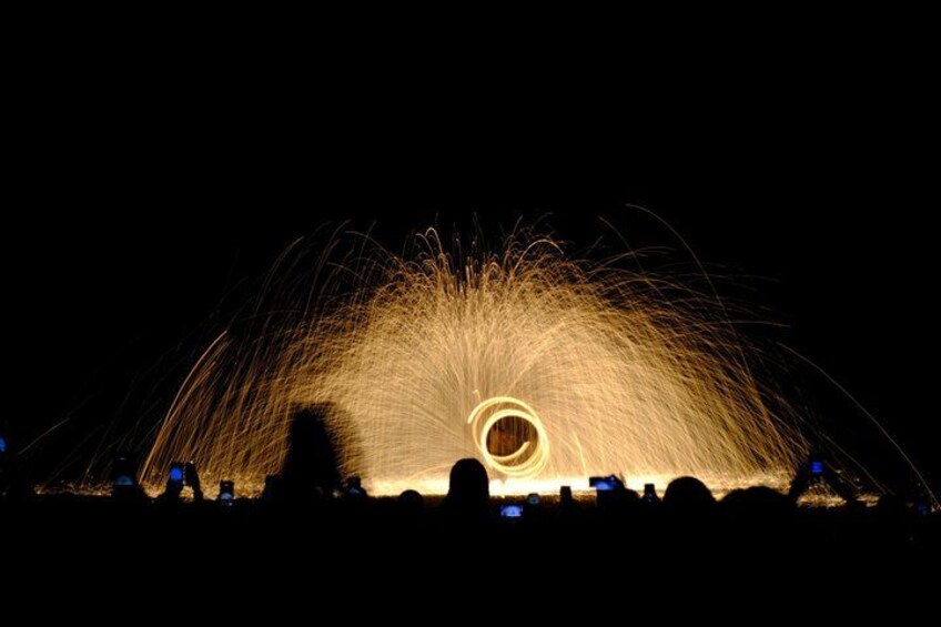 A firework display with sparks and smoke against a dark night sky. 2