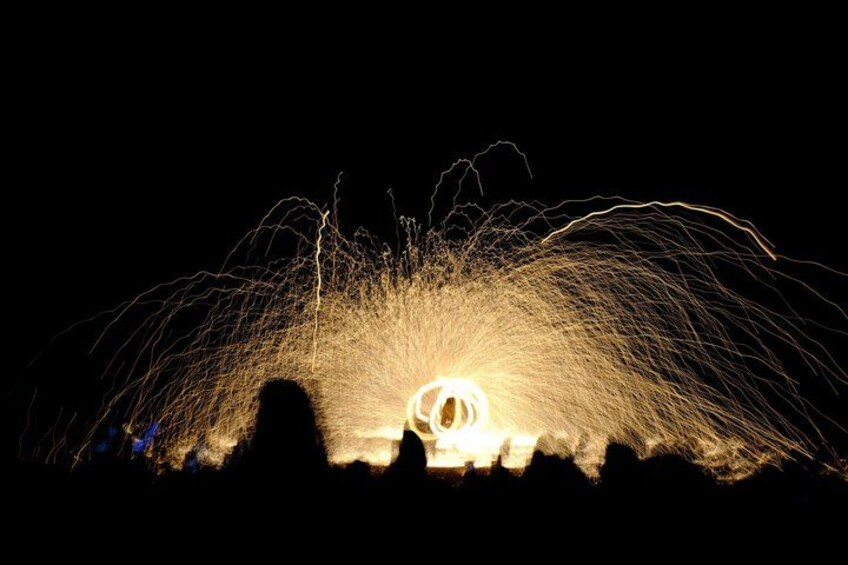 A night scene with a bright light source creating a circular pattern of sparks. 3