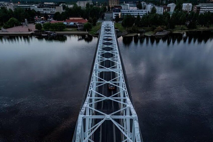 A bridge over a calm river with a cityscape in the background. 4