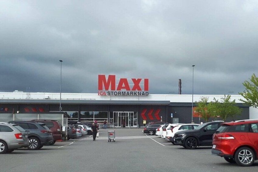 A MAXI store with a parking lot and cars. 3