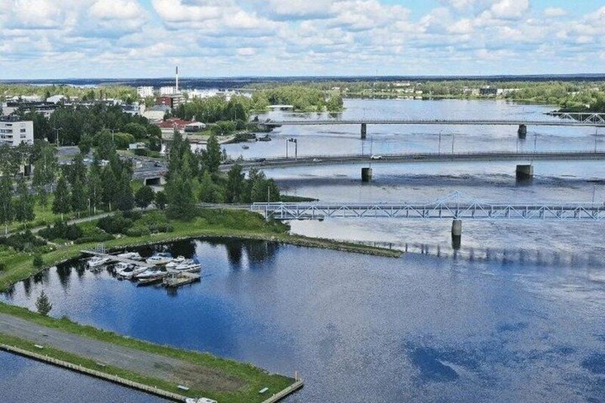 A river with a bridge, a marina, and industrial buildings in the background. 5