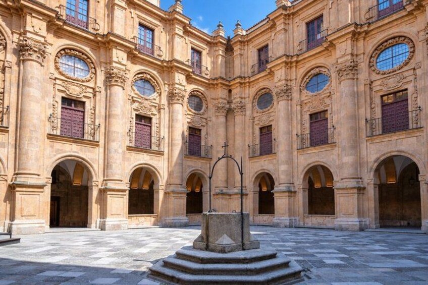 A courtyard with a central fountain, surrounded by ornate buildings with arched windows and balconies. 2