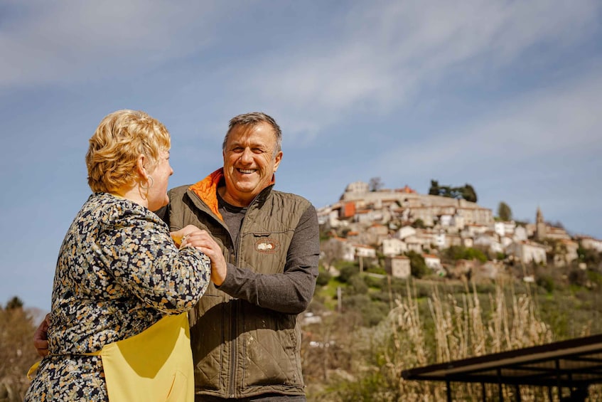 Two people standing outdoors with a historic town in the background. 4