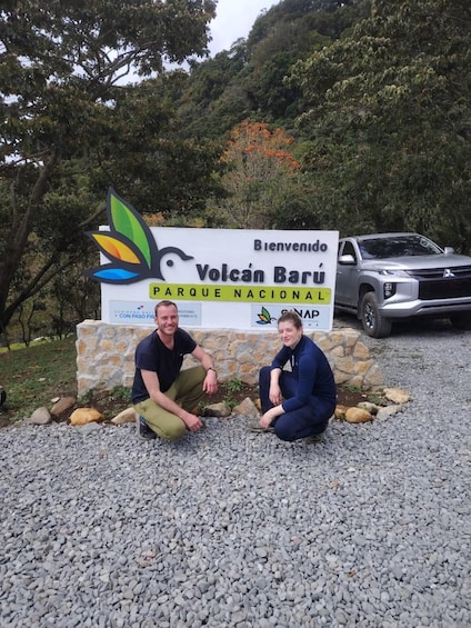 Two people posing in front of a sign for Volcán Barú Parque Nacional. 1