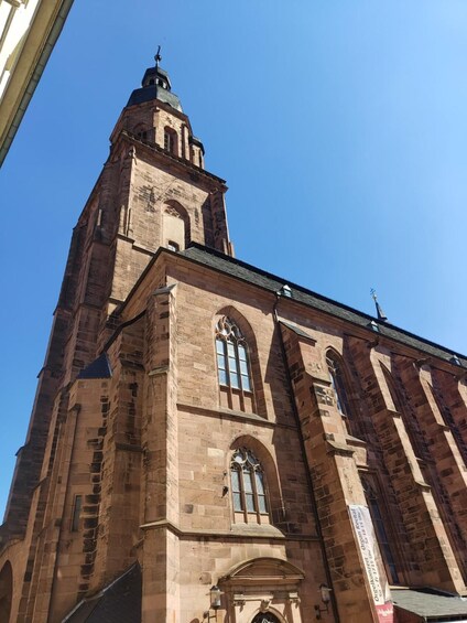 En hög kyrka byggd av tegel, med ett framträdande torn och välvda fönster. 4