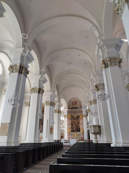En kyrkas interiör med högt tak, välvda fönster och utsmyckade pelare. 2