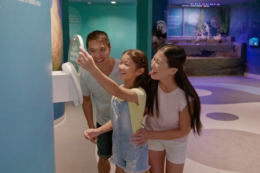A family taking a selfie in a museum with exhibits in the background. 4