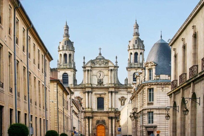 A historic church with two bell towers and a dome, surrounded by classical architecture. 1