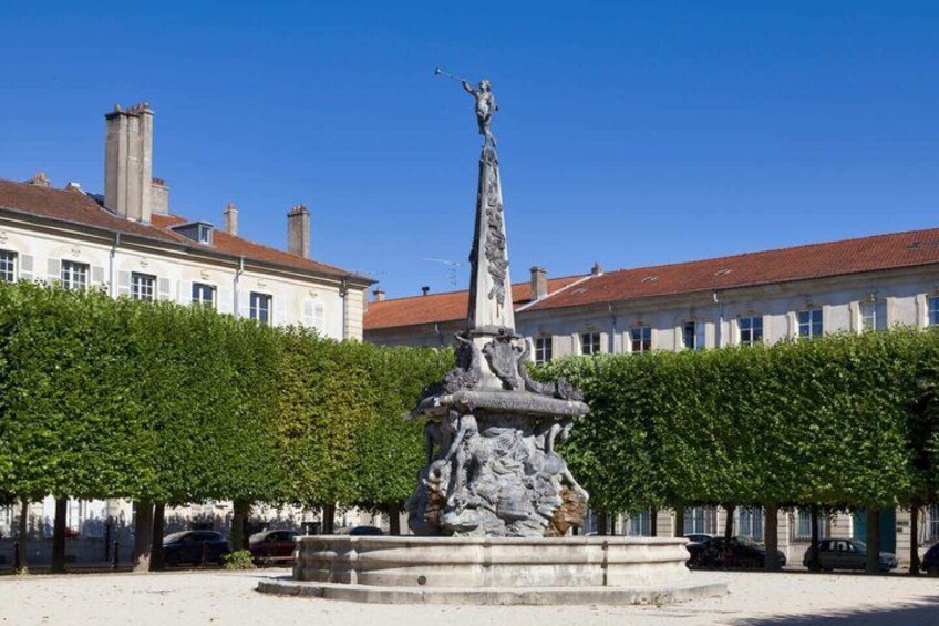 A statue in a square with buildings in the background. 2