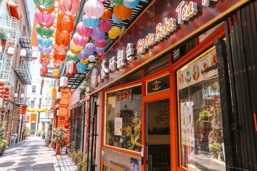 A street with colorful lanterns, a tea shop with an 'OPEN' sign, and traditional Chinese architecture. 3