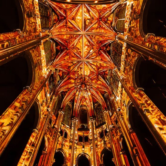 Une vue détaillée de l’intérieur d’une cathédrale, avec ses vitraux complexes aux motifs dorés et rouges, ainsi que ses éléments architecturaux richement décorés. 4