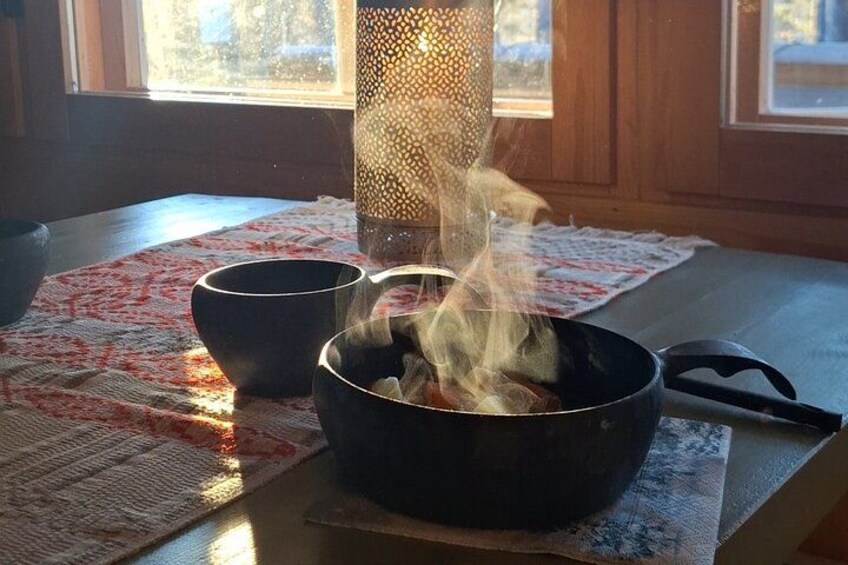 A stove with steam rising from a pot, two bowls, and a patterned placemat on a wooden table. 4