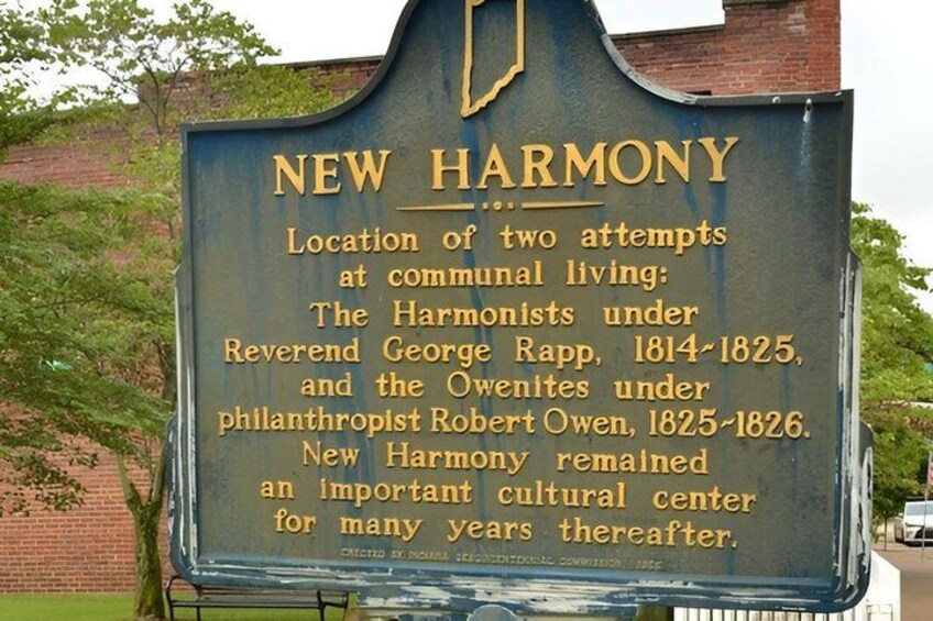 A historical marker sign with text about New Harmony. 1