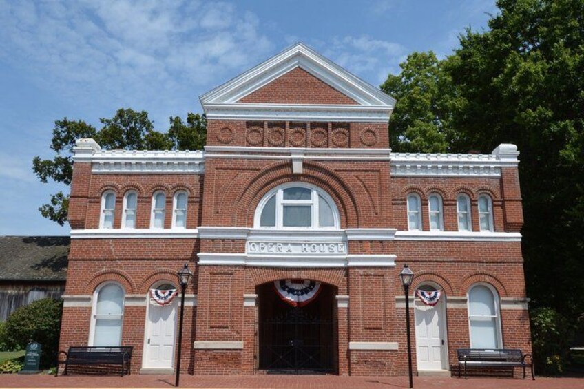 A brick building with arched windows and a sign that reads 'SPEECH HOUSE'. 2
