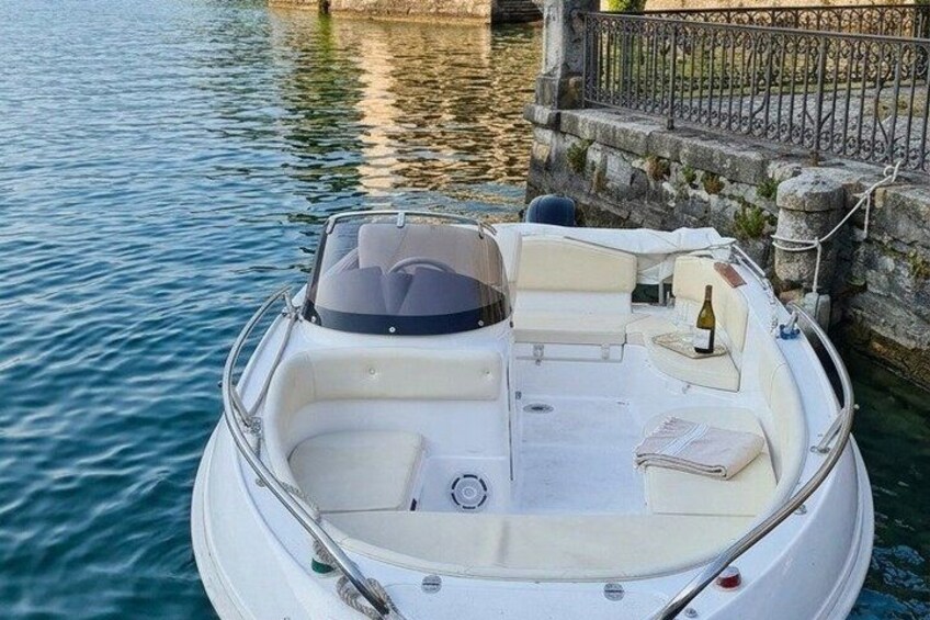 A white motorboat docked at a stone pier with a clear waterway. 5