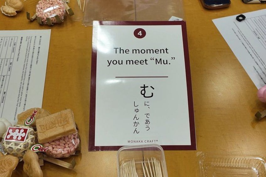 A table with a sign reading 'The moment you meet 'Mu.'' and Japanese text below it. 2