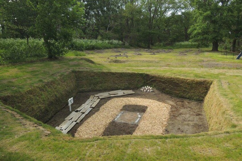 A historical excavation site with wooden planks and a sign. 5