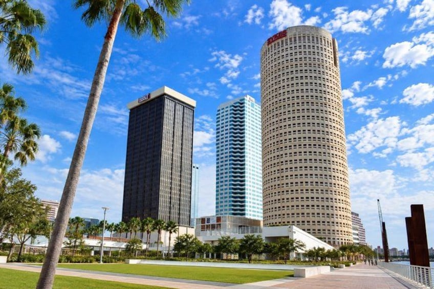 Three tall buildings, palm trees, and a clear blue sky. 1