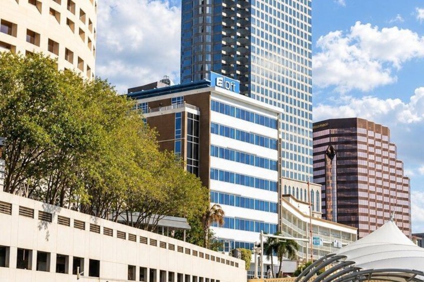 A cityscape with modern buildings, including a tall blue skyscraper with 'Edi' on it, and a white building with a dome. 4