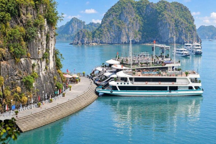 A boat docked at a pier with a mountainous backdrop. 2