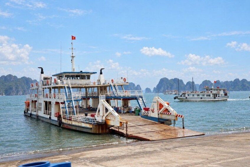 A ferry docked at a pier with a clear sky and calm sea. 5