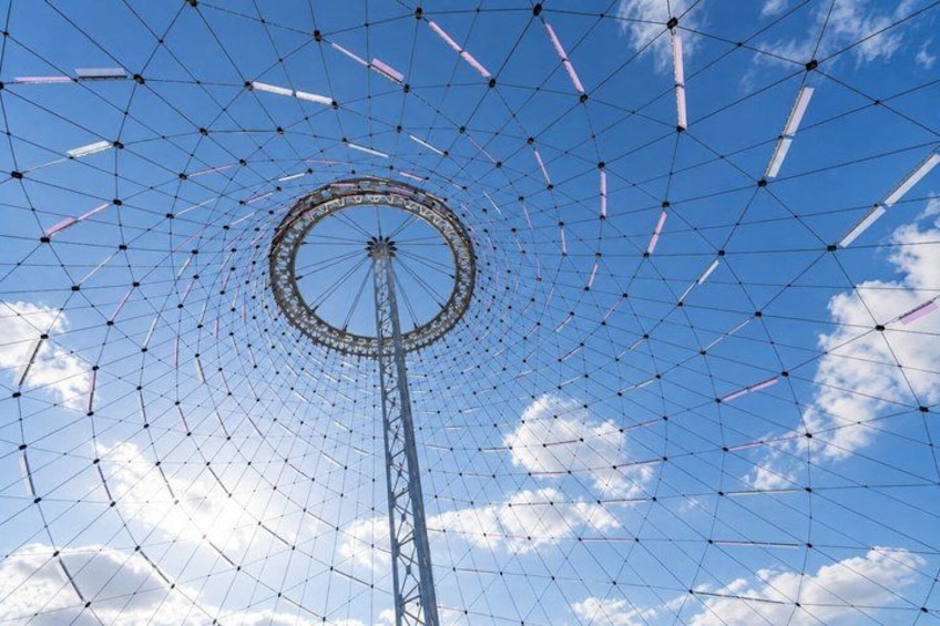 A Ferris wheel with a clear blue sky and clouds in the background. 5