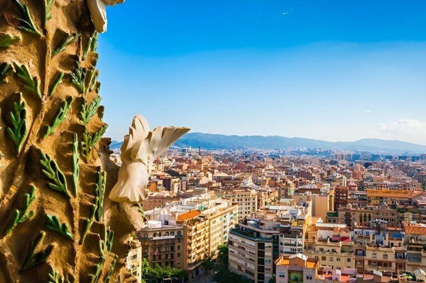 A cityscape with a prominent building featuring a white statue of an angel. 2