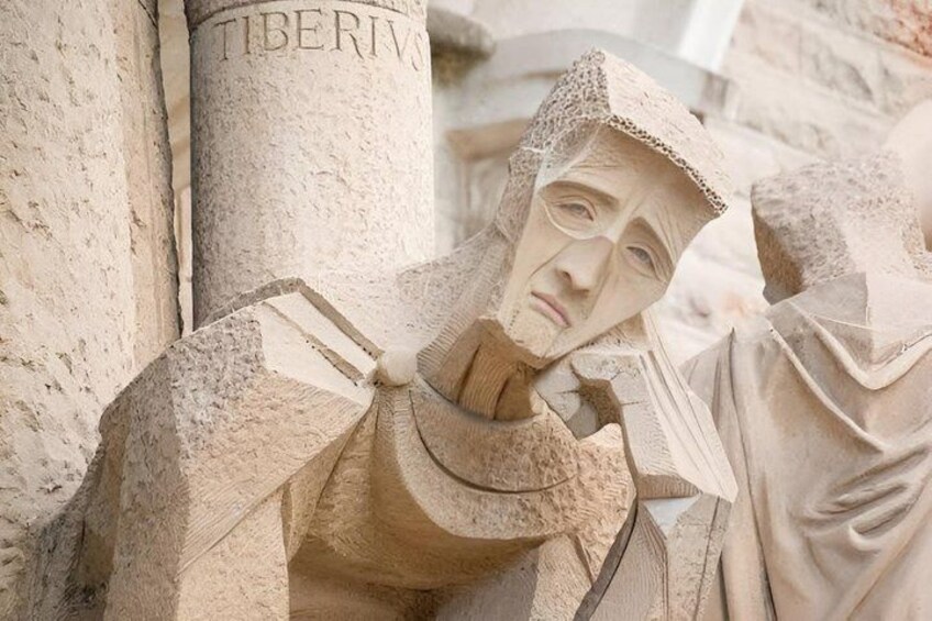 A stone sculpture of a figure with a hood, standing next to a column labeled 'TIBERIVS'. 3
