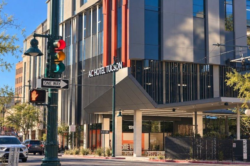 A modern building with a sign for 'AC HOTEL TUSON' and a traffic light. 5