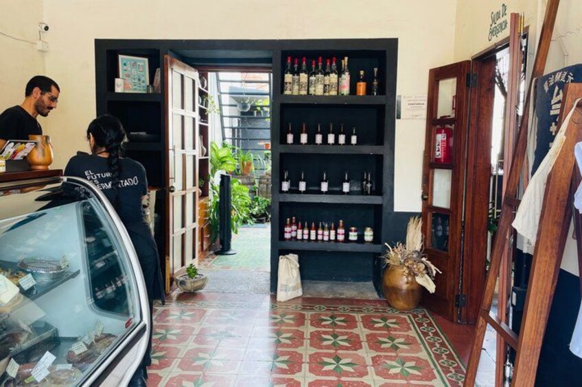 A storefront with shelves of bottles, a car in the foreground, and a tiled floor. 3