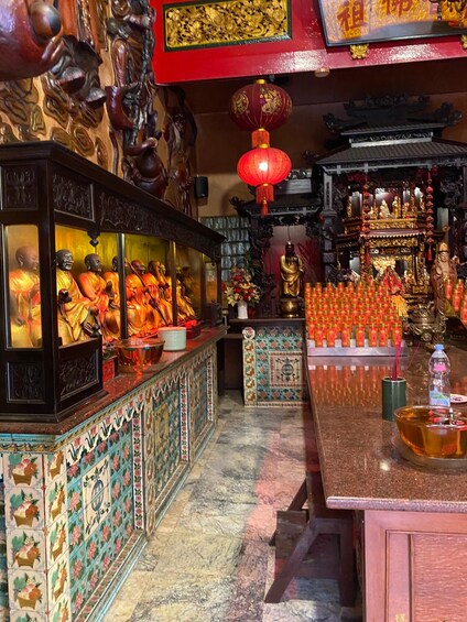 A temple interior with statues, incense burners, and traditional decorations. 5