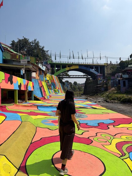 A colorful pedestrian pathway with a bridge in the background. 4