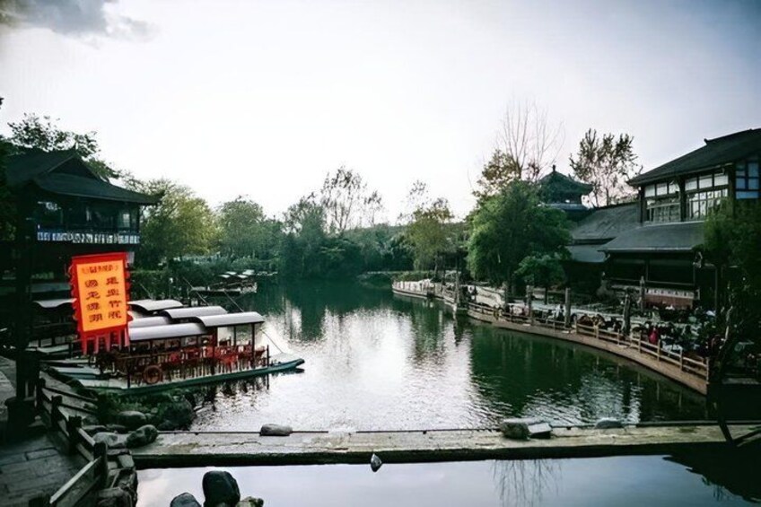 A calm river with traditional buildings and a wooden bridge. 3