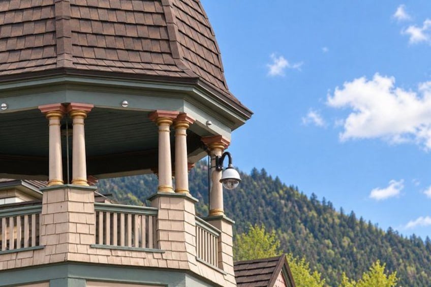 A house with a turret and columns, a mountain in the background, and a clear sky. 2