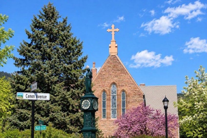A church with a steeple, a clock, and a cross on top. 5
