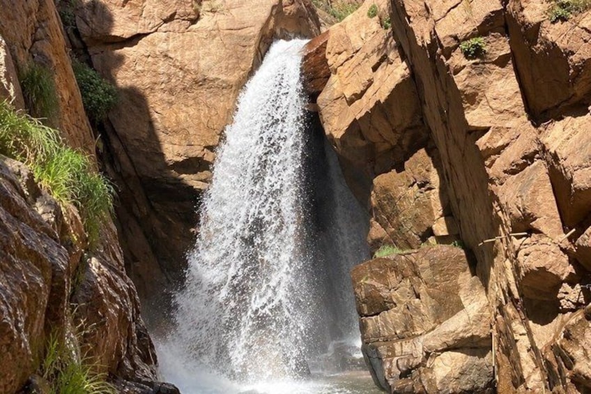 A waterfall cascading down a rocky cliff surrounded by vegetation. 3
