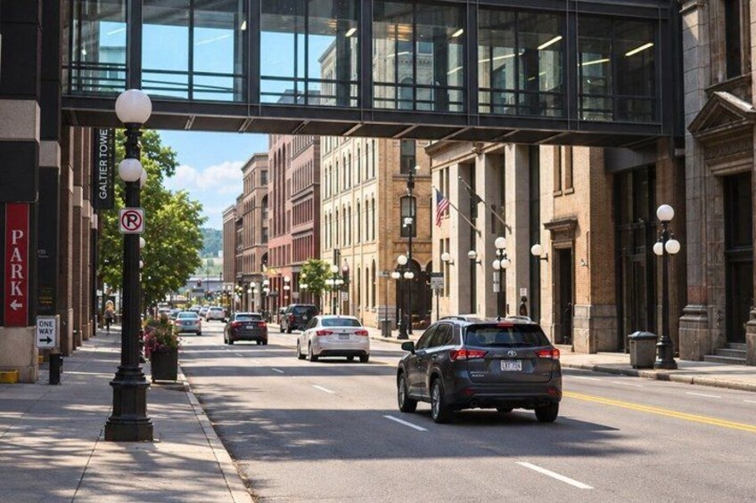 A city street with cars, a pedestrian crossing, and a building with columns. 4