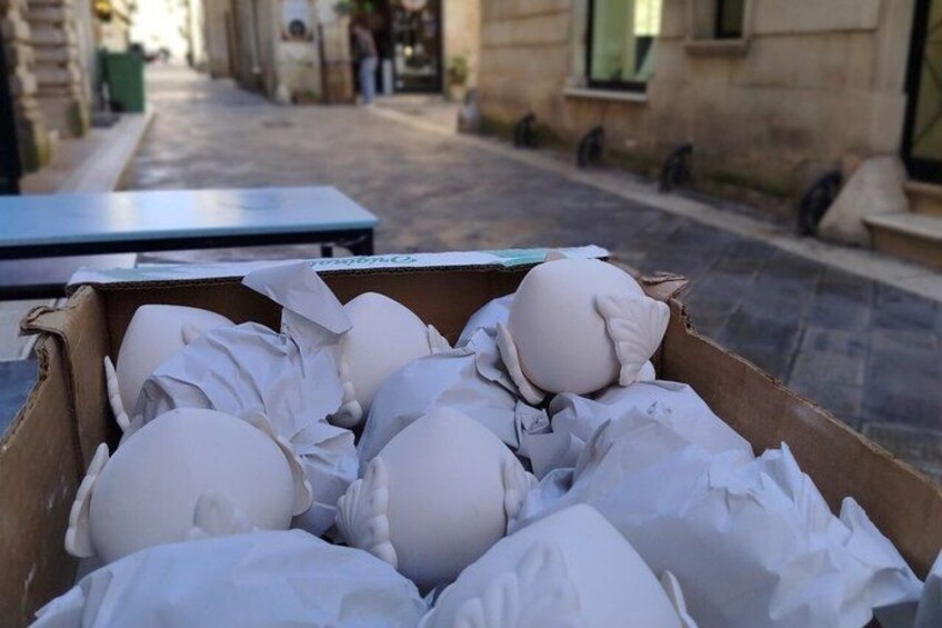 A cardboard box filled with white pillows on a street. 2