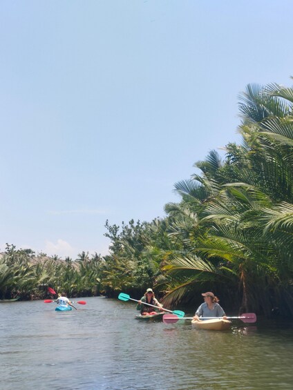 People kayaking on a river surrounded by palm trees. 5