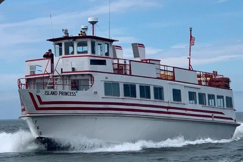 A white boat named 'Island Princess' with red stripes, a cabin, and an American flag. 1