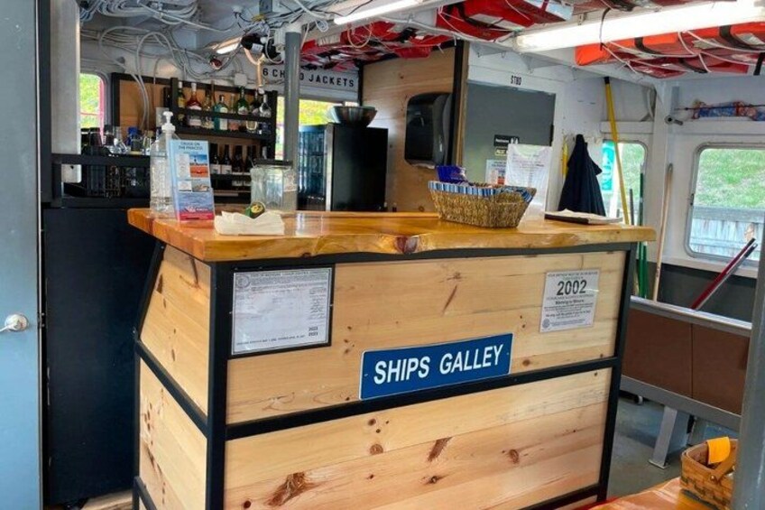 A wooden counter with a sign reading 'SHIPS GALLEY' and a year marker '2002'. 3