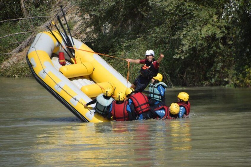 A overturned inflatable raft with people wearing life jackets and helmets. 3